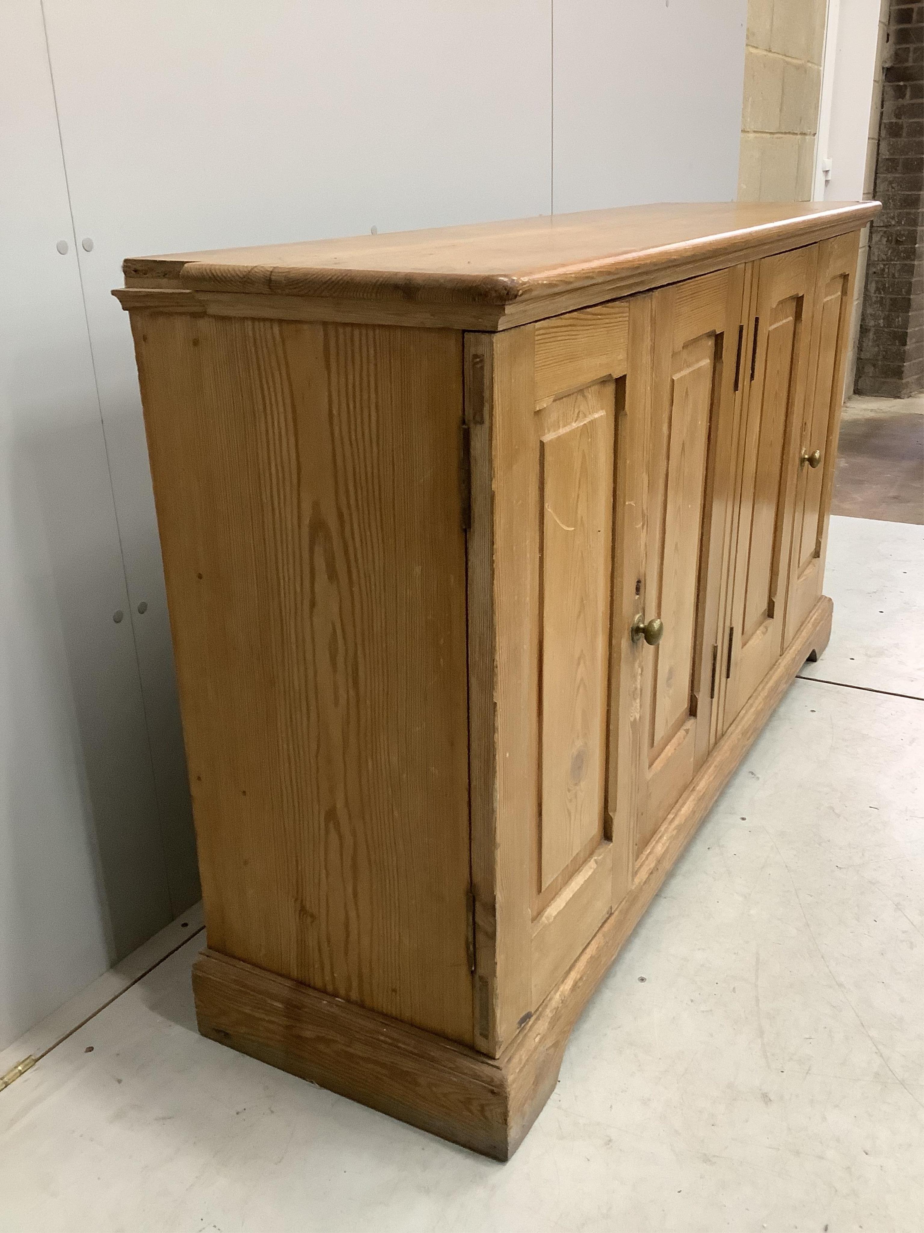 A late Victorian pitch pine four door side cabinet, width 158cm, depth 42cm, height 91cm. Condition - fair